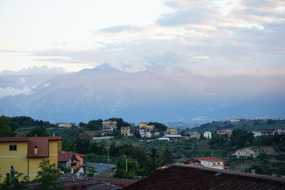 Town by mountains against sky