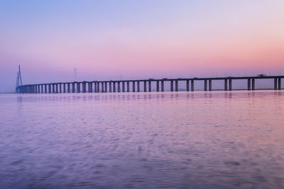 Pier over sea against sky during sunset