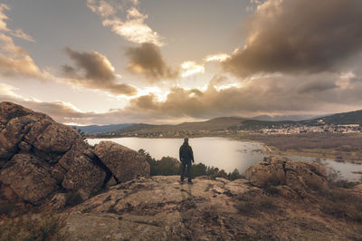 Rear view of man standing on rocks against land