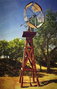 Low angle view of traditional windmill on field against sky