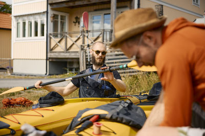 Man sitting in kayak and checking holding paddle