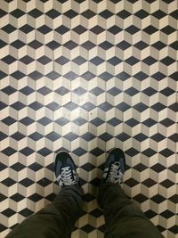 Low section of person standing on tiled floor