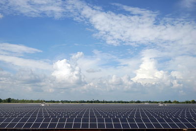 View of photovoltaic solar panal farm against sky