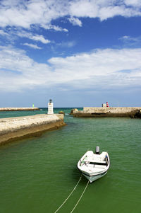 Boat moored at calm blue sea