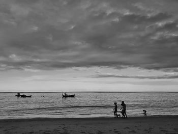 People on beach against sky