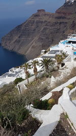 Scenic view of sea by mountain against sky