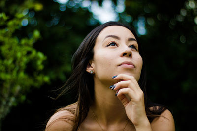 Thoughtful young woman looking up
