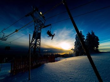 Silhouette of snow against sky during sunset