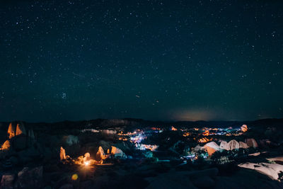 Illuminated camping grounds against sky at night