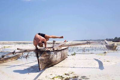 Man standing on beach against clear sky