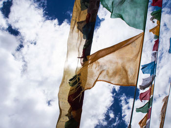 Low angle view of flags hanging against sky