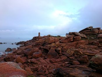 Rocks by sea against sky