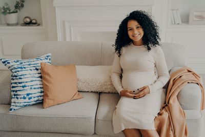 Young woman sitting on sofa at home