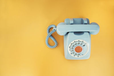 Close-up of telephone booth on table against wall