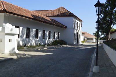 Houses by street against sky in city