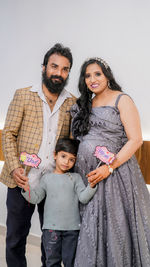 Portrait of smiling couple standing against white background