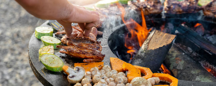 Person preparing food on barbecue grill