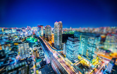 Aerial view of illuminated buildings in city at night