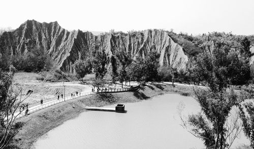 Scenic view of river by mountains against clear sky