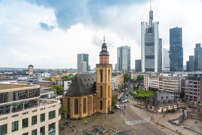 Buildings in city against cloudy sky