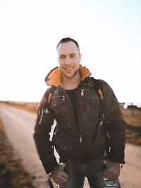 Portrait of smiling young man standing against sky