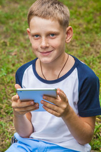 Portrait of smiling boy holding smart phone