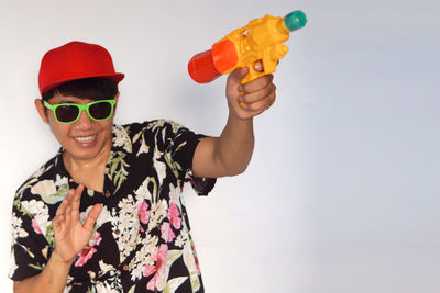 Portrait of smiling young man holding sunglasses