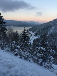 Scenic view of snow covered mountains against sky at sunset