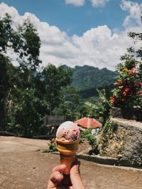 Me, holding ice cream cone against plants