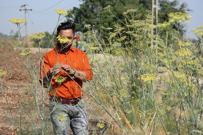 Man holding umbrella standing on field