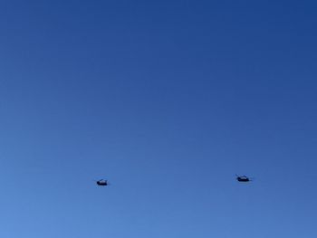 Low angle view of airplane against clear blue sky