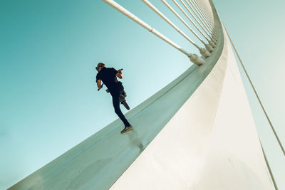 Low angle view of man jumping against sky