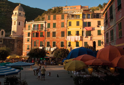 Multi colored parasols against old buildings in town during sunset