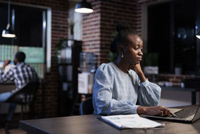 Young woman using laptop at table