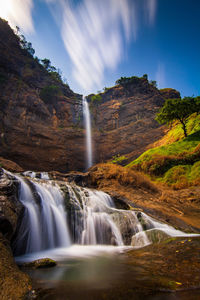 Scenic view of waterfall against sky