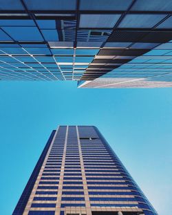 Low angle view of modern building against clear blue sky