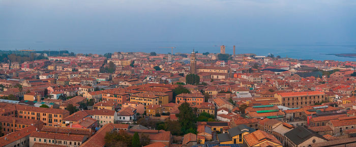 High angle view of townscape by sea against sky
