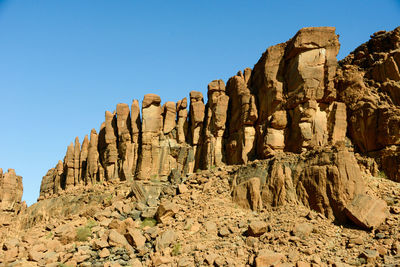 Low angle view of rocks on mountain against sky