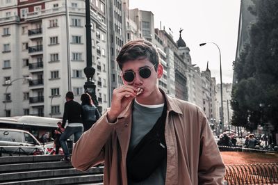 Young man wearing sunglasses standing on city street