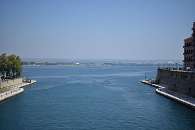 Scenic view of sea by buildings against clear sky