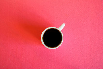 Directly above shot of coffee cup on red table