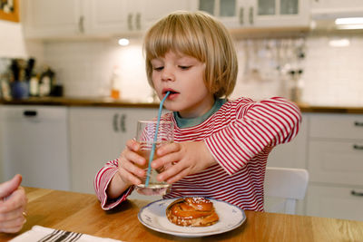 Boy having drink at dining table