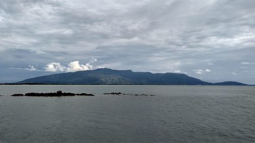 Scenic view of sea and mountains against sky