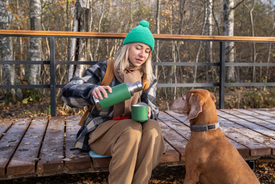 Portrait of young woman using mobile phone while sitting on bench