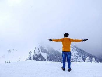 Full length rear view of man standing on snow