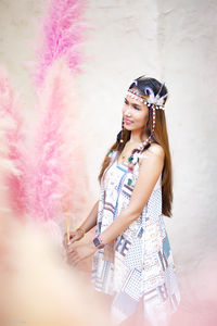 Young woman standing against wall