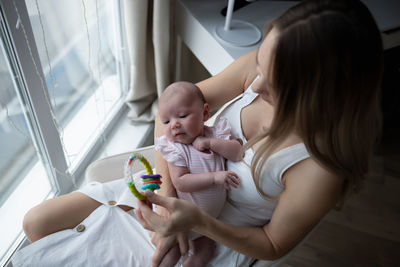 Side view of mother and daughter at home