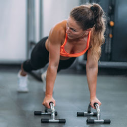 Full length of woman exercising at gym