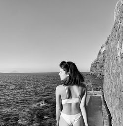 Rear view of woman in bikini against sea