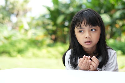 Portrait of young woman sitting on table